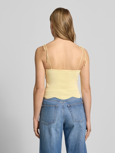Modelka nosi top aus Viskose-Mix mit Spaghettiträgern von LeGer by Lena Gercke, dopasowany krój, model 'Felicitas', cienkie ramiączka z wiązaniem, dekolt w kształcie serca, falisty brzeg, długość tyłu w rozmiarze 36: 25 cm, jasny żółty, gładka tekstura, Ganzkörperansicht Rückansicht.