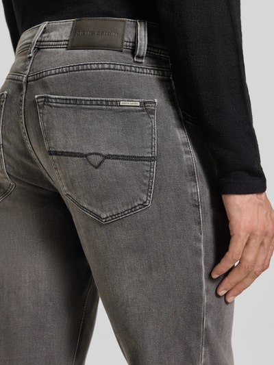 Männermodel trägt Straight Fit Jeans aus elastischem Baumwoll-Mix Modell 'Lyon' von Pierre Cardin in Grau, Used-Look, Nahaufnahme Rückansicht. Herren Jeans, 5-Pocket-Design, Gürtelschlaufen, Knopf- und Reißverschluss, Bundweite 43 cm, Innenbeinlänge 81 cm.