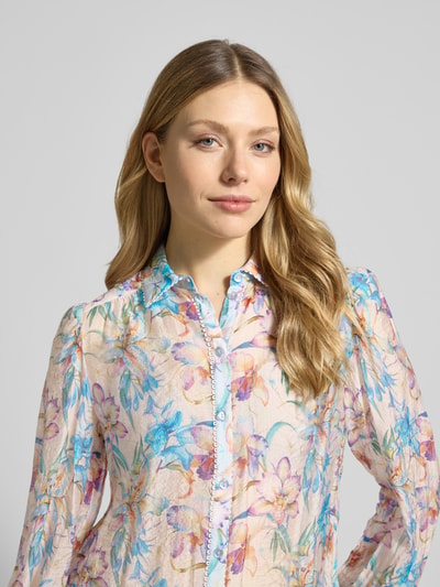 Kobiece modelka nosi Regular Fit Bluzka aus Viskose-Mix mit floralem Muster von Christian Berg Woman Selection, mieszanka wiskozy, krój regular fit, kwiatowy wzór, kołnierzyk koszulowy, listwa guzikowa, długość tyłu w rozmiarze 36: 62 cm, długość rękawów w rozmiarze 36: 66 cm, jasne kolory, miękka tekstura, widok z przodu, zbliżenie na górną część ciała.