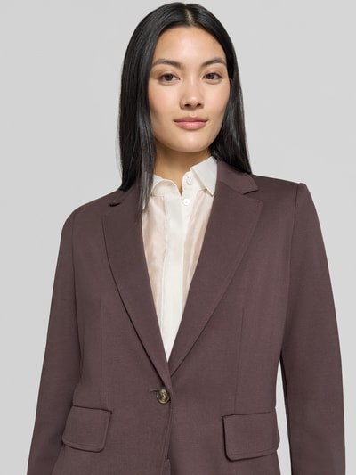 Frauenmodel trägt Blazer aus Viskose-Mix Modell 'Orche' von EMME in Braun mit Pattentaschen, taillierte Passform, Nahaufnahme Oberkörper.