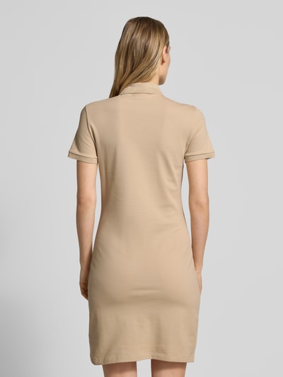 Frauenmodel trägt Slim Fit Polokleid aus Baumwoll-Mix von Lacoste in unifarbener Optik, Mini-Länge, hochgeschlossen, Ganzkörperansicht Rückansicht.