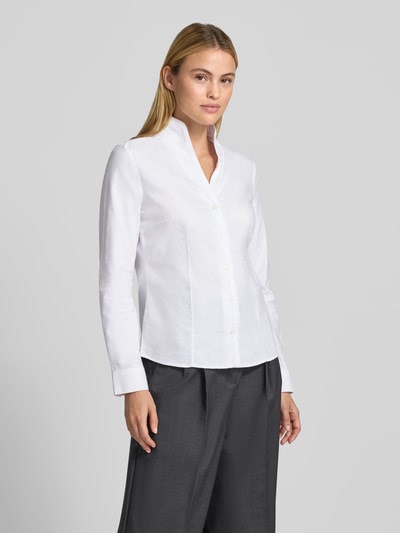 Frauenmodel trägt Regular Fit Hemdbluse aus reiner Baumwolle von Christian Berg Woman, weiß, Stehkragen, Langarm, Ganzkörperansicht von vorne.