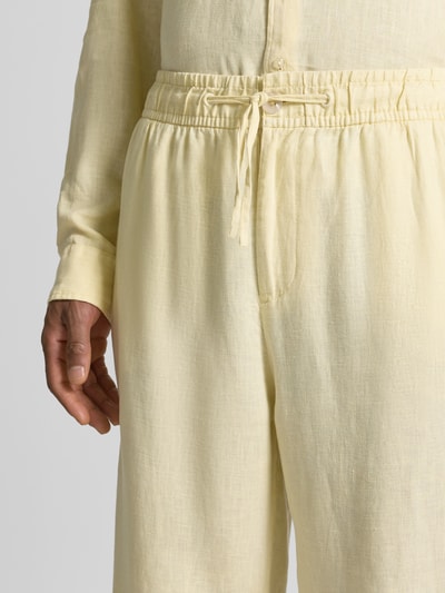 Männermodel trägt Leinenhose mit elastischem Bund von MCNEAL in Hellgelb, reine Leinen, Regular-Fit, Tunnelzug, Nahaufnahme Oberkörper.
