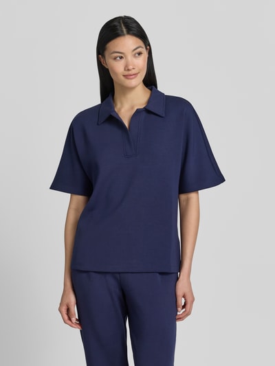 Modelka kobieca nosi Regular Fit Poloshirt mit V-Ausschnitt von Christian Berg Woman, granatowy, materiał z domieszką modalu, półrękaw, gładka tekstura, widok całej sylwetki z przodu.