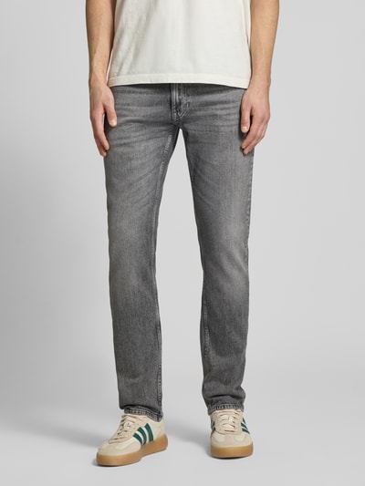 Männermodel trägt Slim Fit Jeans aus Baumwoll-Mix Modell 'SCANTON' von Tommy Jeans, grauer Denim mit 5-Pocket-Design, Ganzkörperansicht von vorne.