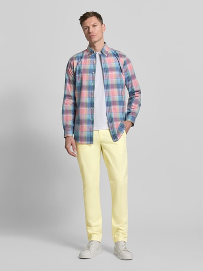 Männermodel trägt Slim Fit Chino mit Eingrifftaschen von MCNEAL aus elastischem Baumwoll-Mix in Gelb, Ganzkörperansicht von vorne.