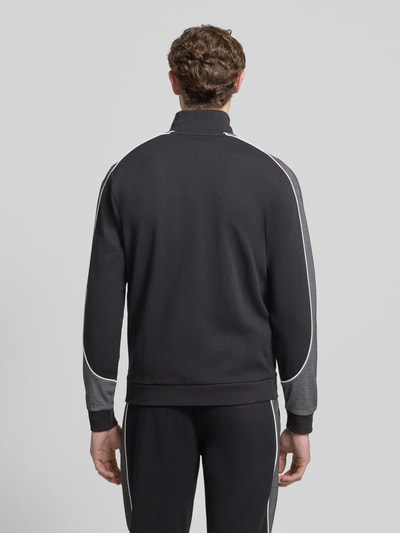 Männermodel trägt Regular Fit Sweatshirt aus Baumwoll-Mix von BOSS in Optik: Unifarben mit Galonstreifen und Label-Applikation, Ganzkörperansicht Rückansicht.