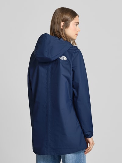 Modelka nosi Regular Fit Parka mit Logo-Print Modell 'Antora' od The North Face, niebieski, kaptur ze ściągaczem, wąskie rękawy, kieszenie, długość tyłu w rozmiarze S: 74 cm, szerokość ramion: 39 cm, szerokość w rozmiarze S: 50 cm, długość rękawa: 64 cm, widok całej sylwetki z tyłu.