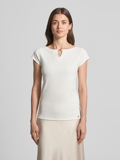 Modelka kobieca nosi T-Shirt mit Cut Out od Marc Cain, modal z domieszką stretchu, prosty krój, drobny prążek, okrągły dekolt, biała, długość tyłu w rozmiarze 36: 56 cm, widok całej sylwetki z przodu.