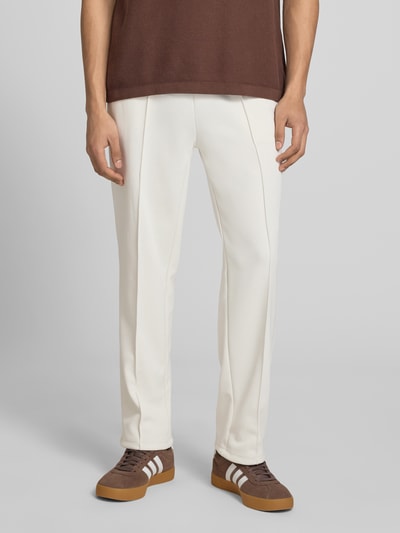 Männermodel trägt Trackpants mit Längsnähten Modell 'Motus' von Pegador, Relaxed-Fit, Baumwoll-Mix, Innenbeinlänge 75 cm, Ganzkörperansicht von vorne.