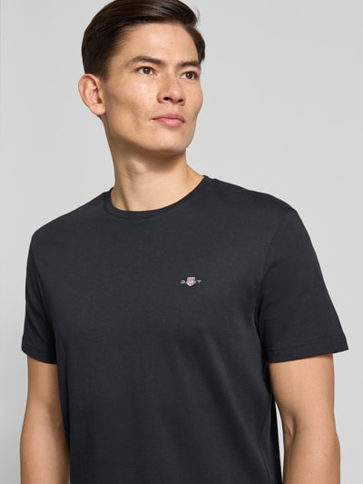 Männermodel trägt Regular Fit T-Shirt mit Label-Stitching Modell 'SHIELD' von GANT in Unifarben-Design aus reiner Baumwolle, Nahaufnahme Oberkörper.