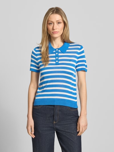 Vrouwenmodel draagt Regular Fit Poloshirt uit Lyocell-Seide-mix van Tommy Hilfiger met all-over streeppatroon, korte mouwen, fijngebreid, logo-stitching, polokraag en korte knoopsluiting, vooraanzicht van het bovenlichaam.