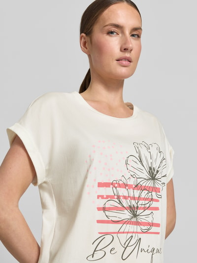 Vrouwenmodel draagt T-Shirt met fixeerde mouwomslag Model 'RINA' van Soyaconcept, recht fit, ronde hals, katoenmix, motiefprint, detailopname bovenlichaam.