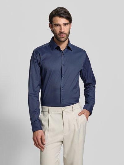 Männermodel trägt Regular Fit Businesshemd aus Stretch-Twill Modell 'P-JOE-KENT-C1-222' von BOSS in Dunkelblau, Ganzkörperansicht von vorne.