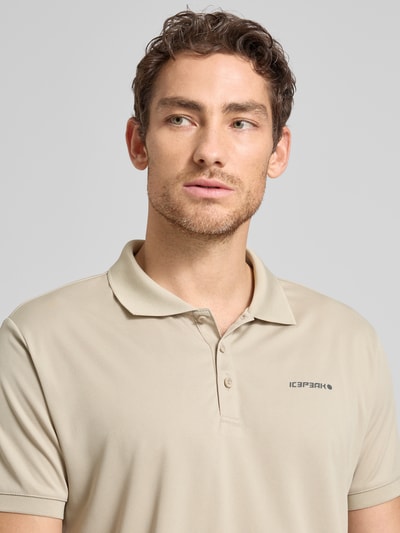 Męski model nosi Regular Fit koszulka polo z nadrukiem z logo, model 'BELLMONT' od Icepeak, kołnierzyk polo, krótki rękaw, długość tyłu w rozmiarze M: 73 cm, jasnobeżowy, gładka faktura, prosty krój, nahaufnahme górnej części ciała.