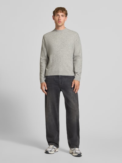 Männermodel trägt Relaxed Fit Strickpullover aus Material-Mix mit Baumwoll-Anteil von REVIEW in Hellgrau, Ganzkörperansicht von vorne.