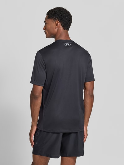 Männermodel trägt schwarzes Regular Fit Sport-T-Shirt mit Label-Print von Under Armour, glatte Textur, Ganzkörperansicht Rückansicht, Herren Sport-T-Shirt von Under Armour.