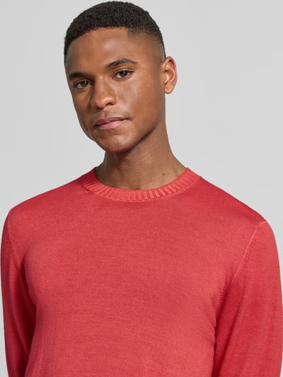 Männermodel trägt Strickpullover aus reiner Schurwolle von GRAN SASSO in Rot, körpernaher Schnitt, Nahaufnahme Oberkörper.