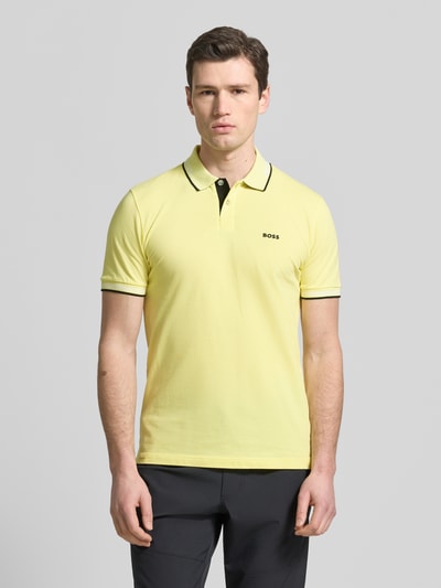 Männermodel trägt Slim Fit Poloshirt aus reiner Baumwolle Modell 'PAUL' von BOSS Green, Optik: Unifarben, Ganzkörperansicht von vorne.