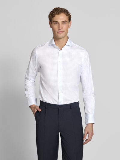 Männermodel trägt Slim Fit Business-Hemd aus reiner Baumwolle von Christian Berg Men, weiß gemustert, Ganzkörperansicht von vorne. Herrenhemd, Haikragen, durchgängige Knopfleiste, langärmelig, leicht strukturierte Oberfläche, Maße laut Kontext.