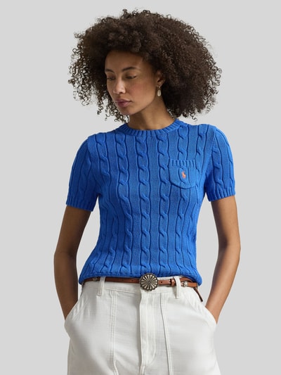 Modelka kobieca nosi Slim Fit Kurzarmpullover mit Label-Stitching od Polo Ralph Lauren, kolor niebieski, bawełna, faktura dzianiny, okrągły dekolt, kieszonka na piersi z logo, elastyczne wykończenia, krój slim fit, szwy widoczne, długość pleców 55 cm, długość rękawa 20 cm, widok całego ciała z przodu