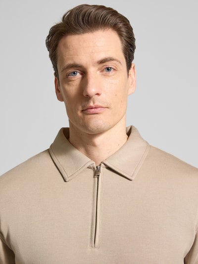 Männermodel trägt Regular Fit Poloshirt aus Viskose-Mix Modell 'EMANUEL' von SELECTED HOMME, beige, Sweat-Optik, Nahaufnahme Oberkörper.