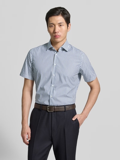 Männermodel trägt Regular Fit Business-Hemd mit Kentkragen von Christian Berg Men, Reine Baumwolle, Knopfleiste, 1/2-Arm, Ganzkörperansicht von vorne.
