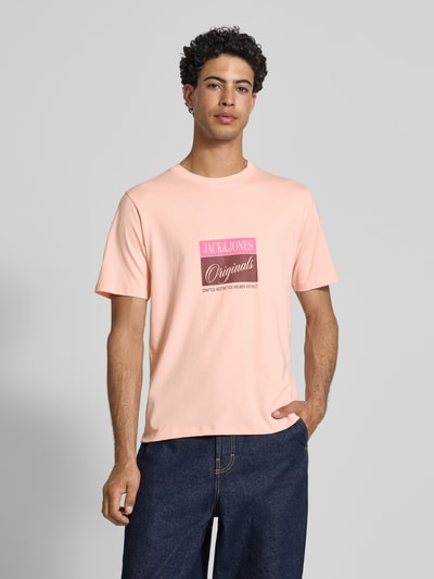 Männermodel trägt T-Shirt mit Statement-Print Modell 'RHYERES' von Jack & Jones in Pfirsich, reine gewachste Baumwolle, Nahaufnahme Oberkörper.