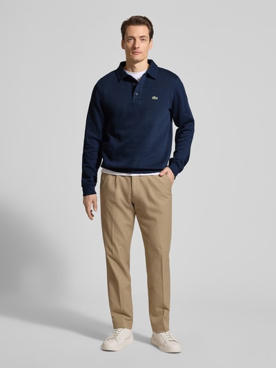 Männermodel trägt Regular Fit Sweatshirt aus reiner Baumwolle von Lacoste in Optik: Unifarben, Logo-Stitching, Polokragen, Ganzkörperansicht von vorne.