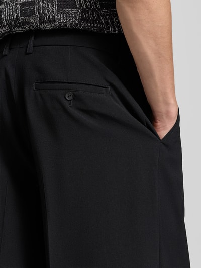 Mannenmodel draagt Relaxed Fit Stoffhose aus Woll-Mix van Filippa K, zwart met steek- en achterzakken, detailopname rechterzij.
