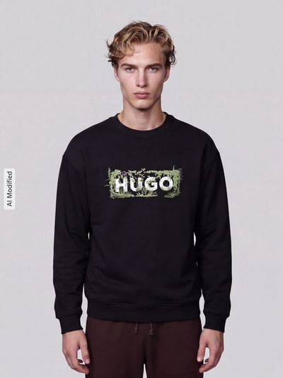 Männermodel trägt Relaxed Fit Sweatshirt aus reiner Baumwolle Modell 'Niviocrew' von HUGO, jednokolorowy, kwiatowy wzór, nadruk z logo, wyhaftowany motyw, okrągły dekolt, długi rękaw, prążkowane wykończenia, dzianina dresowa, Materiał: bawełna, Ganzkörperansicht von vorne, KI-modifiziertes Bild.
