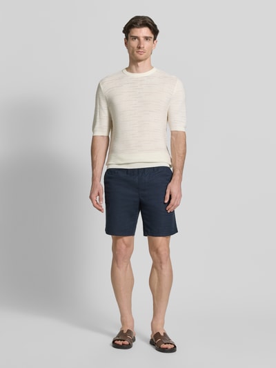 Männermodel trägt Strickshirt aus Baumwolle von Antony Morato in Beige, gerader Schnitt, Rundhals, Halbarm, Ganzkörperansicht von vorne
