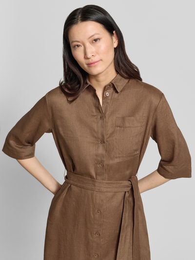 Modelka kobieca nosi sukienkę koszulową z lnu z brustaszą model 'LTABELLA' od MM by Max Mara, taliowany krój, sukienka midi, kołnierzyk koszulowy, listwa guzikowa, wiązany pasek, kolor brązowy, długość tyłu w rozmiarze 36: 122 cm, szerokość w rozmiarze 36: 52 cm, długość rękawów w rozmiarze 36: 36 cm, tekstura lnu, zbliżenie na górną część tułowia, widok z przodu.