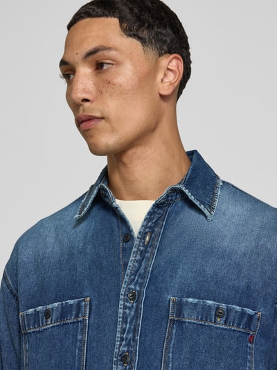 Männermodel trägt Regular Fit Jeanshemd mit Viskose-Anteil von Replay, indigoblau, Brusttaschen, Nahaufnahme Oberkörper.