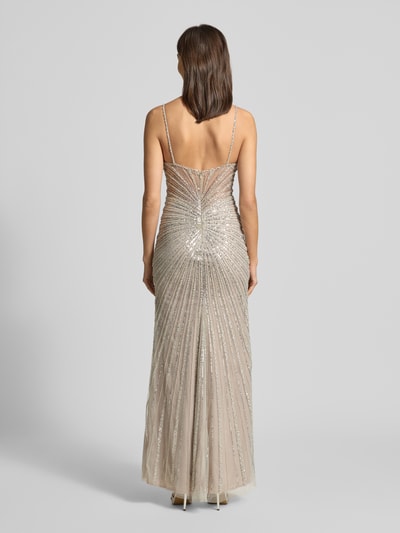 Frauenmodel trägt Slim Fit Abendkleid mit Allover-Ziersteinbesatz von Hey Kyla, semitransparent, Spaghettiträger, Nahtreißverschluss, blickdichter Unterrock, silbrig-beige Struktur, Rückansicht Ganzkörperansicht.