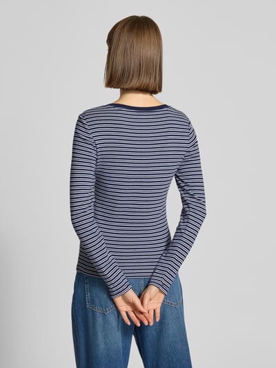 Modelka kobieca nosi Slim Fit Longsleeve mit Logo-Stitching Modell 'Essential' od Levi's®, bawełna, ciemnoniebieskie paski, widok całej sylwetki z tyłu.