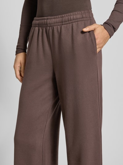 Frauenmodel trägt Wide Fit Sweatpants mit elastische Bund von Gina Tricot, Baumwoll-Mix, Relaxed Fit, braun, Nahaufnahme Oberkörper.