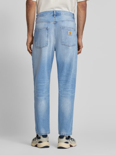 Männermodel trägt Jeans im Used-Look Modell 'Maitland Den' von Carhartt Work In Progress in Hellblau, Relaxed-Fit, Reine Baumwolle, Bundweite bei Größe 32: 46 cm, Innenbeinlänge bei Größe 32: 76 cm, Ganzkörperansicht Rückansicht.