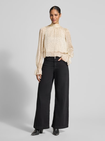 Frauenmodel trägt Regular Fit Bluse im Stufen-Look Modell 'LURDES' von Mango mit Stehkragen und Punktemuster, Ganzkörperansicht von vorne.