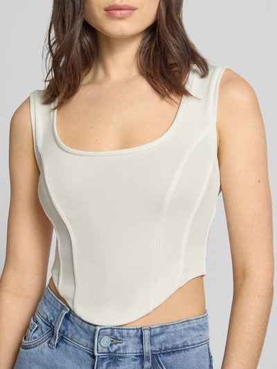 Modelka nosi top Crop Top mit Rundhalsausschnitt Modell 'AGAPA' von Drykorn, mieszanka materiałów z dodatkiem streczu, krój krótki, okrągły dekolt, długość tyłu w rozmiarze S: 22 cm, jasny kolor, gładka tekstura, przód, zbliżenie na górną część ciała.