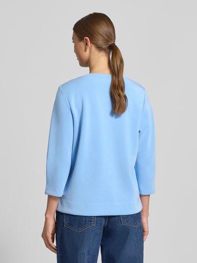 Frauenmodel trägt Comfort Fit Sweatshirt aus Modal-Mix von s.Oliver RED LABEL in Hellblau, unifarben, 3/4-Arm, Ganzkörperansicht Rückansicht.