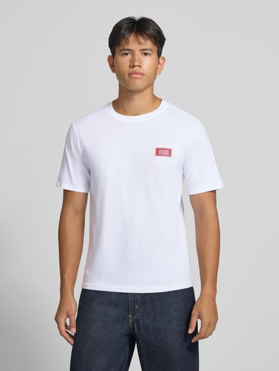Männermodel trägt Regular Fit T-Shirt aus reiner Baumwolle mit Label-Detail von JACK & JONES, weiß, glatte Textur, Ganzkörperansicht von vorne. Rückenlänge bei Größe M: 67 cm, Rundhalsausschnitt.