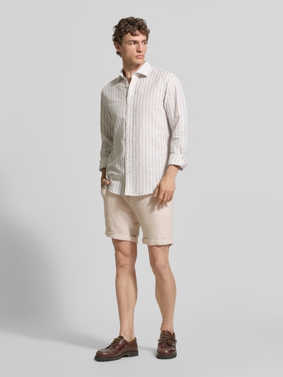 Mężczyzna model nosi Leinenshorts mit Bindegürtel und Gesäßtaschen od MCNEAL z lnu, krój straight fit, jasny beż, widok całej sylwetki z przodu, kontekst: pasek wiązany, zapięcie na guzik i zamek błyskawiczny, wpuszczane kieszenie francuskie, zakładki na nogawkach, z tyłu kieszenie z wypustką zapinane na guzik, wyhaftowane logo z tyłu, szerokość w rozmiarze M: 45 cm, długość wewnętrzna nogawki w rozmiarze M: 16 cm.