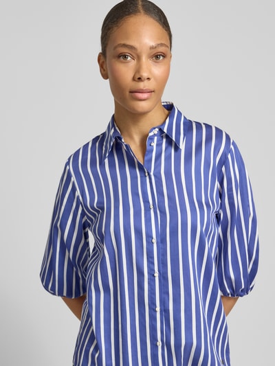 Frauenmodel trägt Regular Fit Bluse mit 3/4-Arm von Marc Cain in Blauweiß mit Allover-Streifen und Hemdblusenkragen, Nahaufnahme Oberkörper.