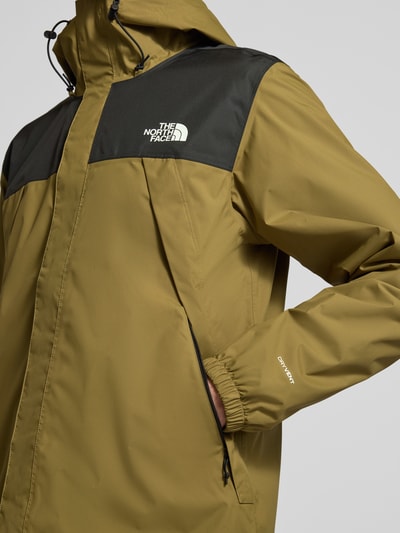 Mężczyznę model nosi Regular Fit Kurtka z nadrukiem z logo model 'Antora' od The North Face, khaki-czarna, wpuszczane kieszenie, kaptur z tunelem, elastyczne zakończenia rękawów, materiał gładki, widok z przodu detaliczny.