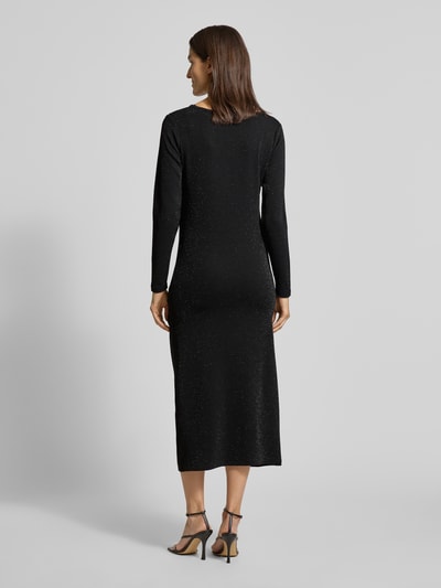 Kobieta modelka nosi długą sukienkę Maxikleid mit Rundhalsausschnitt Model 'ANDINE' od Soyaconcept, mieszanka wiskozy i metalu, taliowany krój, długi rękaw, jednolity czarny kolor z delikatnym połyskiem, widoczna struktura materiału, widok całej sylwetki z tyłu.