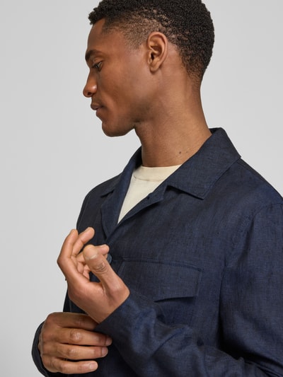 Männermodel trägt Hemdjacke aus Leinen mit Pattentaschen von Zuitable, Regular-Fit, Reverskragen, Knopfleiste, Nahaufnahme Oberkörper.
