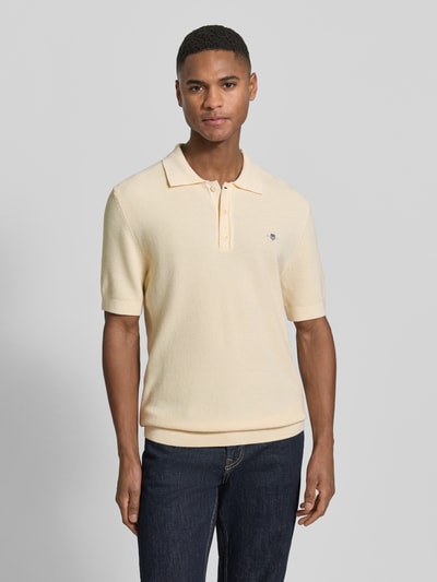Męski model nosi Regular Fit Poloshirt mit Label-Stitching od Gant z bawełny, kołnierzyk polo, kremowy, krój regular fit, przód, zdjęcie całopostaciowe