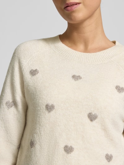 Vrouwenmodel draagt Regular Fit gebreide pullover met intarsia model 'DOFFY INTARSIA' van Vero Moda, effen look, all-over motief, labelstitching, ronde hals, lange mouw, geribde mouwboord en rompzoom, knitwear. Nahaufnahme oberkörper.