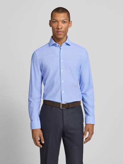 Männermodel trägt Slim Fit Business-Hemd mit Haifischkragen von SEIDENSTICKER aus blauem Material-Mix mit Stretch-Anteil, Ganzkörperansicht von vorne. Rückenlänge bei Größe 40: 77 cm, Schulterbreite: 42 cm, Ärmellänge: 66 cm, Knopfleiste.